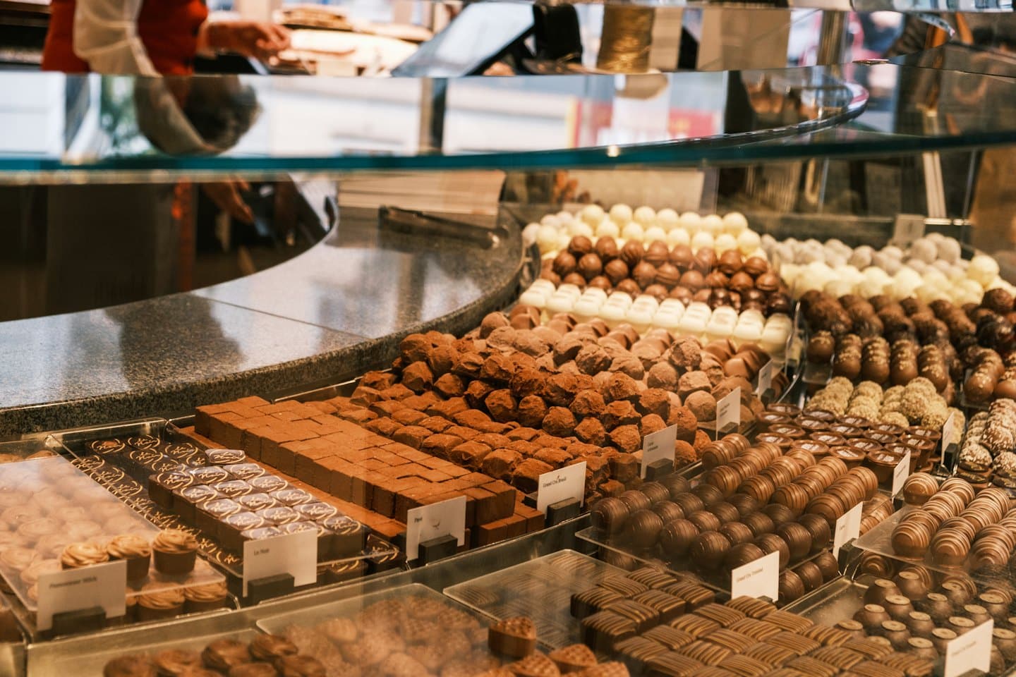 Artisanal chocolates and truffles displayed in a glass counter.